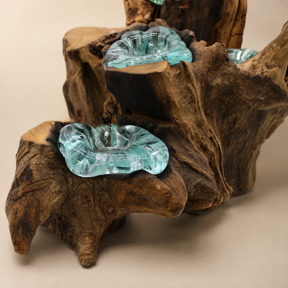 Gros plan sur le bois Gamal naturel et les coupelles irrégulières en verre bleu-vert du bougeoir Néria Quintet.