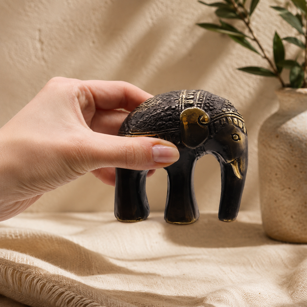 Éléphant décoratif Amara noir et doré tenu à la main pour montrer ses dimensions