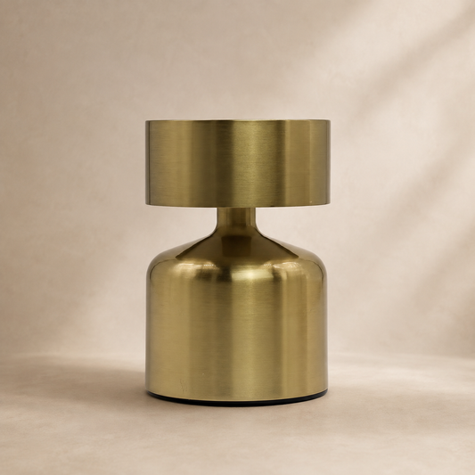 Lampe Noma bronze vue de face sur fond beige, au design compact et minimaliste.
