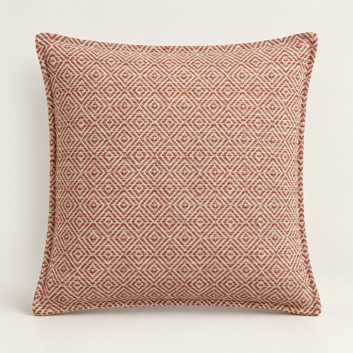 Housse de coussin Naëla 45 × 45 cm en coton, motif de petits carrés géométriques et teinte terracotta poudrée.