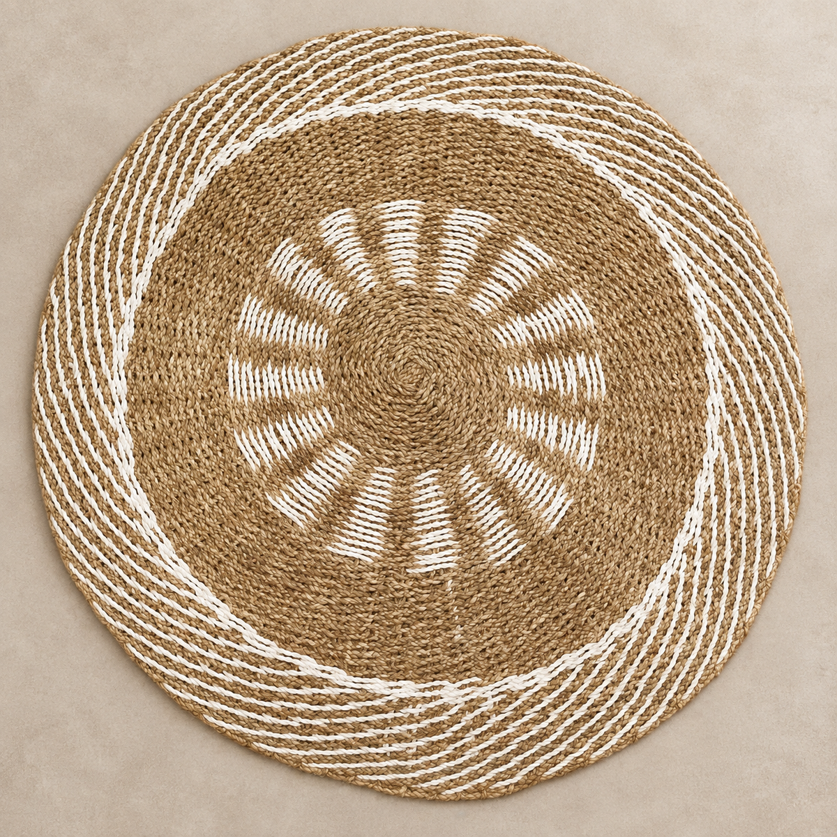 Vue de dessus du tapis Soléa rond en jonc de mer naturel et écru avec motif solaire graphique.