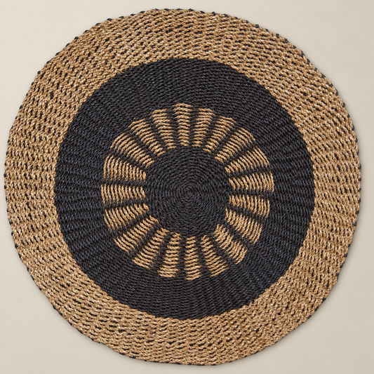 Vue de dessus du tapis rond Soléa Ø 100 cm en jonc de mer naturel et charbon avec motif solaire graphique.