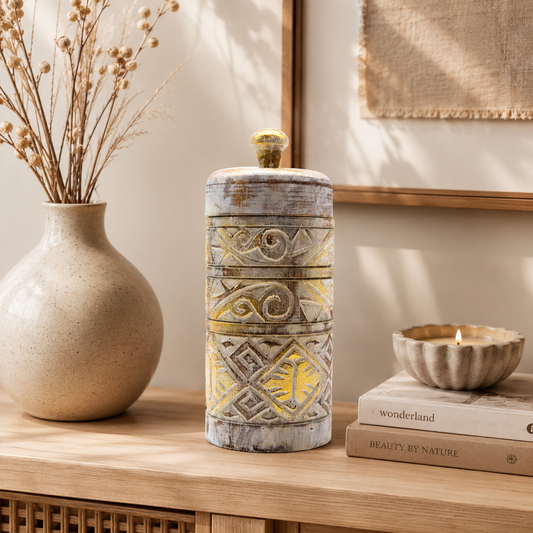 Boîte décorative Alta en blanc patiné et doré mise en scène sur un meuble en bois avec une décoration naturelle.