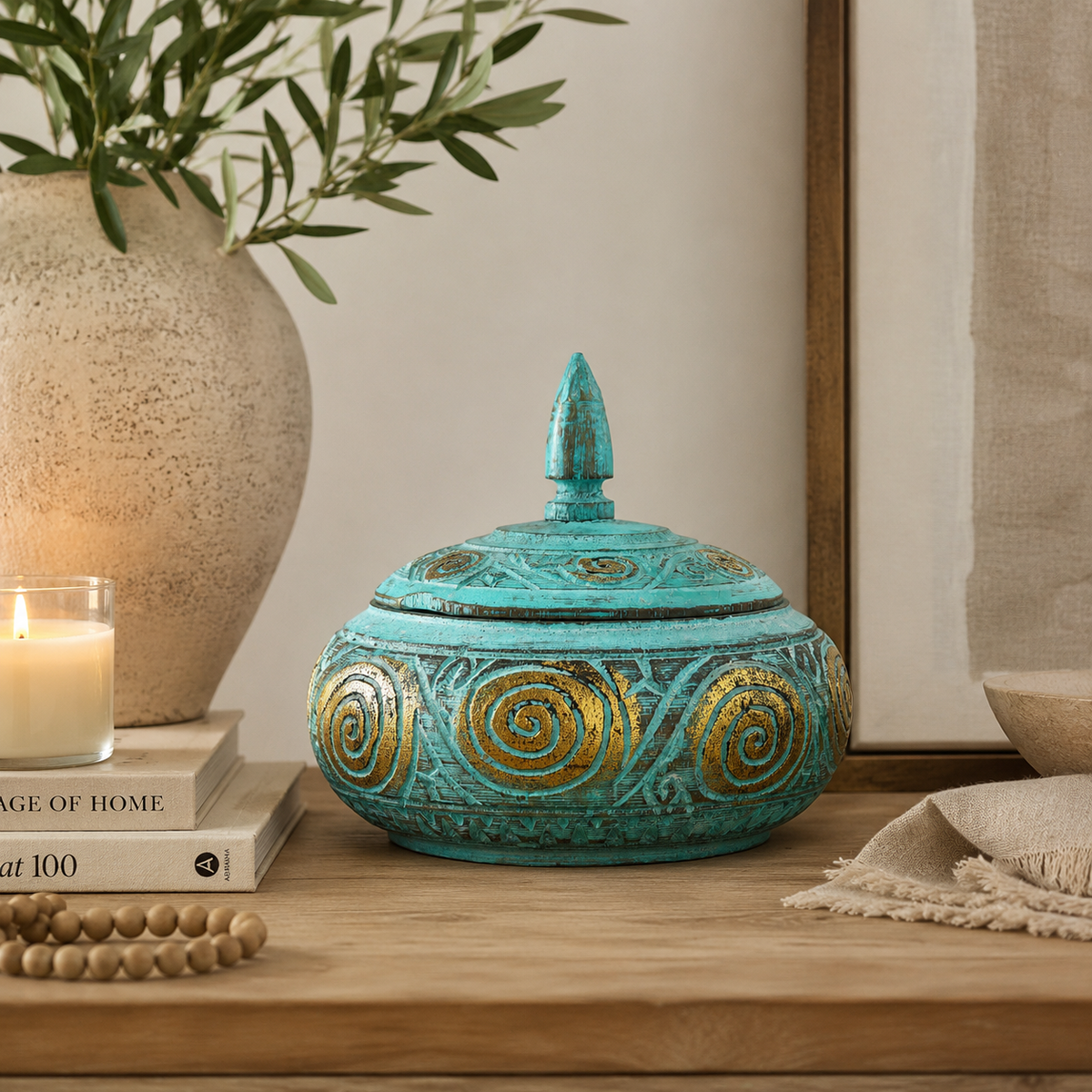 Boîte décorative Azura turquoise et dorée mise en scène sur un meuble dans un intérieur élégant et naturel.