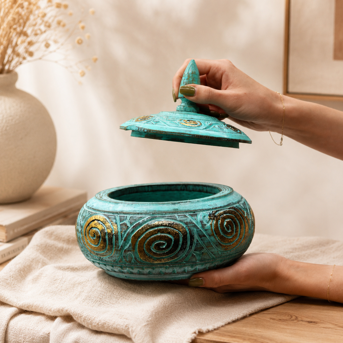 Boîte décorative Azura manipulée à la main, montrant son ouverture et ses proportions dans un décor chaleureux.
