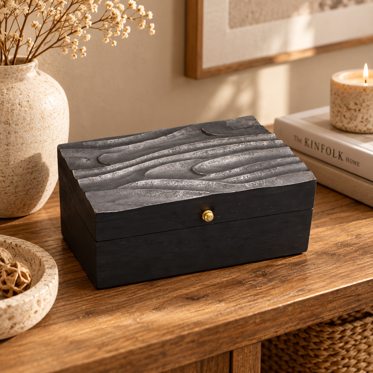 Boîte décorative Veyra aux volutes noires mise en scène sur un meuble dans un intérieur chaleureux