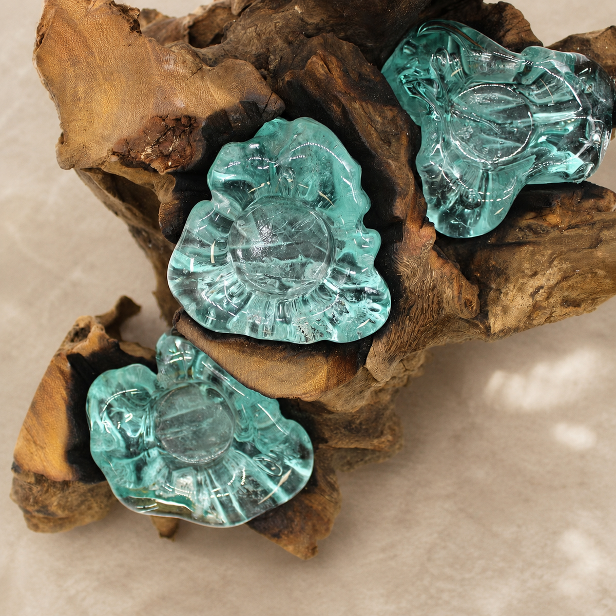Détail des coupelles en verre bleu-vert façonnées directement sur le bois Gamal du bougeoir Néria Quintet.