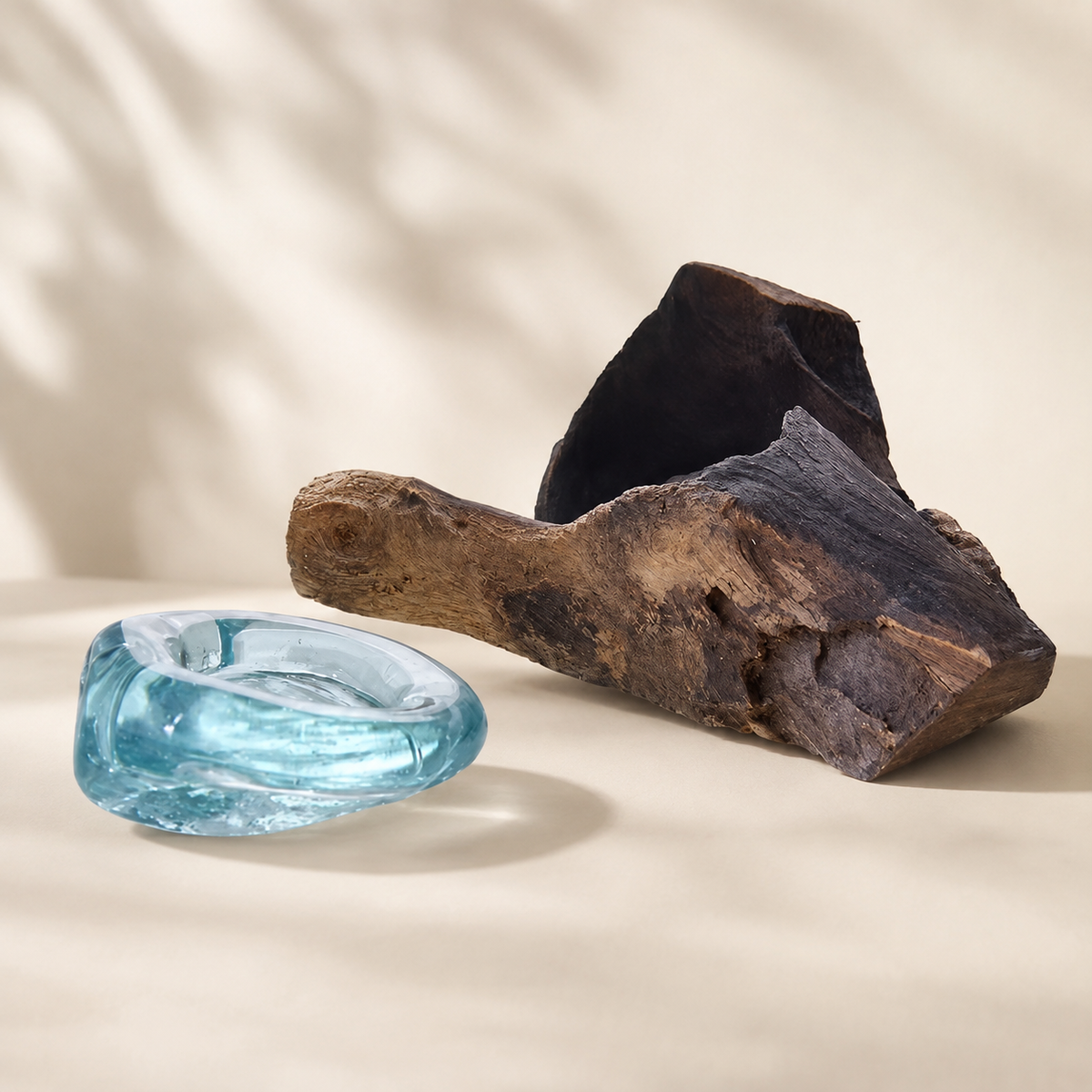 Verre soufflé bleu-vert du Bougeoir Soléa présenté à côté de sa base en bois Gamal