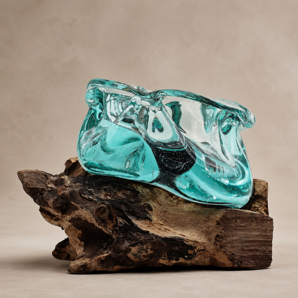 Vue de profil de la Coupelle Aroa en verre soufflé bleu-vert reposant sur sa base en bois Gamal