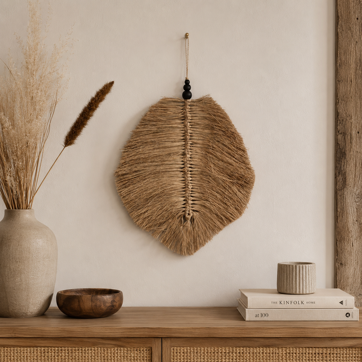 Décoration murale Aïna en raphia suspendue au mur au-dessus d’une console dans une ambiance bohème naturelle