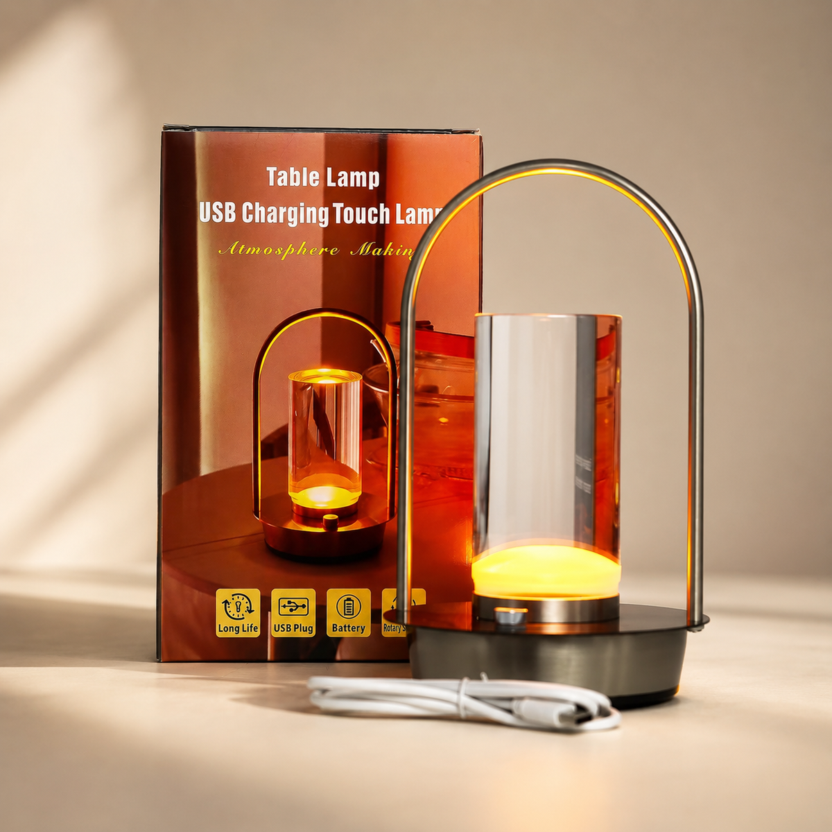 Lampe Noma Crystal allumée avec son emballage et son câble USB, présentée sur fond beige.