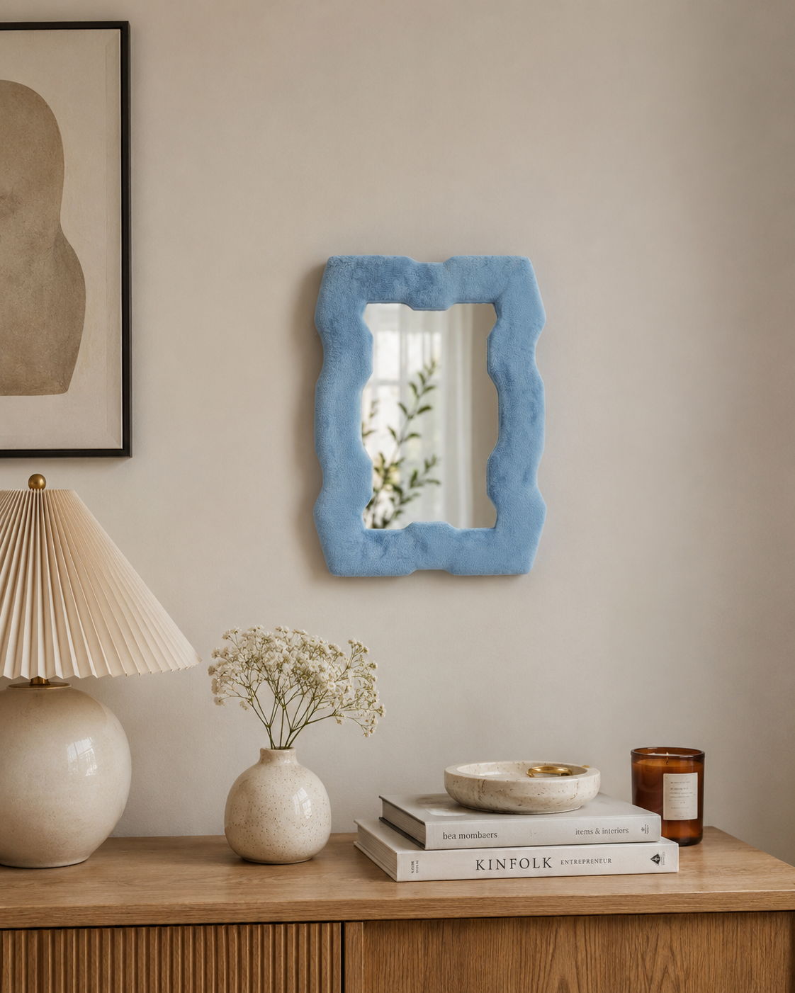Miroir Alma Bleu azur en velours installé au mur dans un intérieur chaleureux