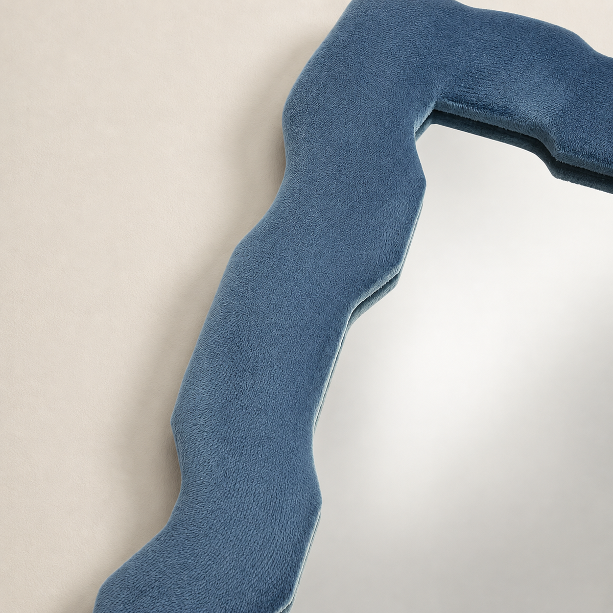 Gros plan sur le cadre épais en velours bleu azur du miroir Alma