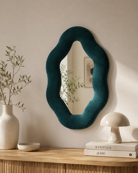 Miroir Alma Émeraude en velours installé au mur dans un intérieur chaleureux