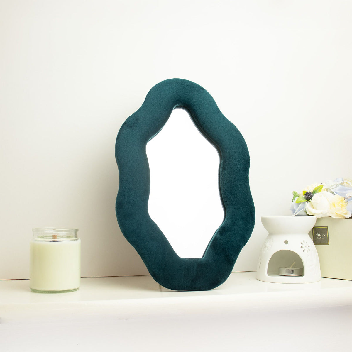 Miroir Alma Émeraude posé sur un meuble dans une décoration aux tons naturels