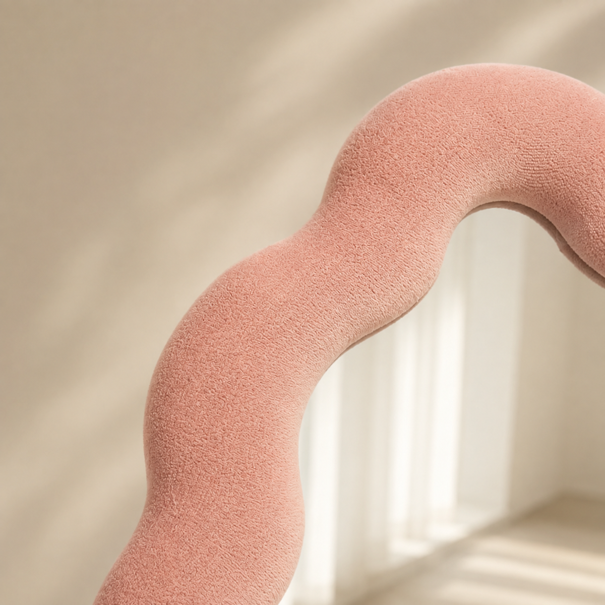 Gros plan sur le cadre ondulé en velours rose poudré du miroir Alma