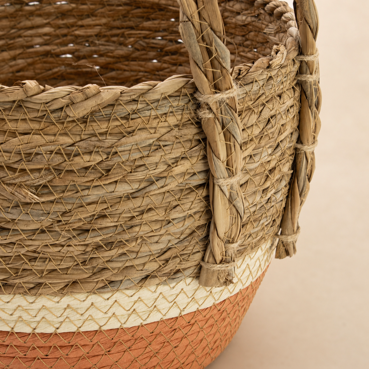 Détail du tressage et de la poignée du panier Caléa en fibres naturelles et terracotta