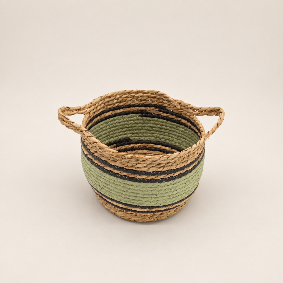 Petit panier Vahéa tressé en fibres naturelles avec bandes vertes et noires et poignées intégrées.