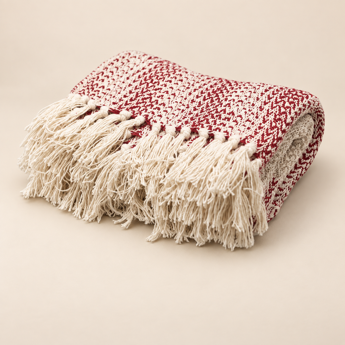 Plaid Elya rubis et écru plié, avec son tissage bicolore texturé et ses longues franges écrues.