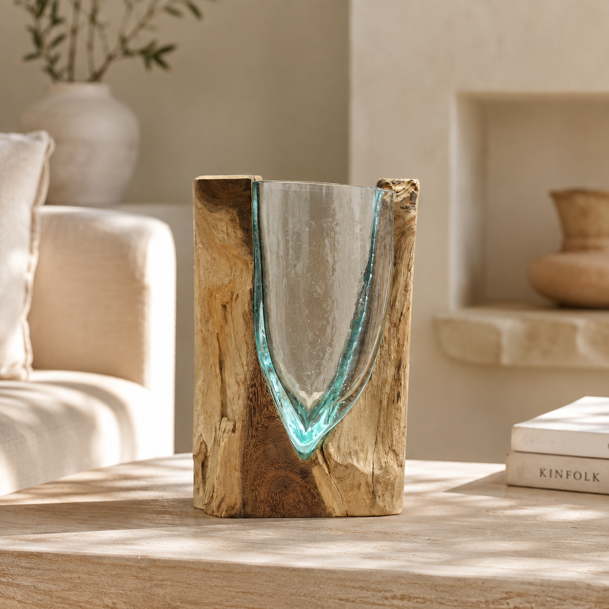 Vase Orwell décoratif en verre aux reflets bleu-vert et bois naturel posé sur un meuble